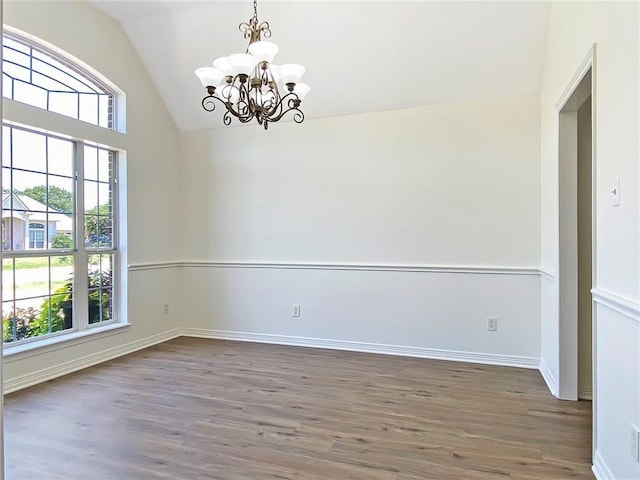 spare room with lofted ceiling, a notable chandelier, and dark hardwood / wood-style floors