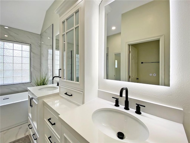 bathroom with vanity and a washtub