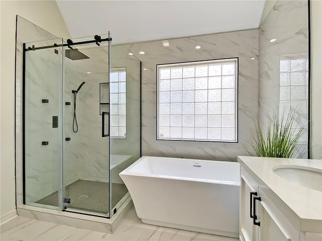 bathroom with vanity, shower with separate bathtub, and tile walls