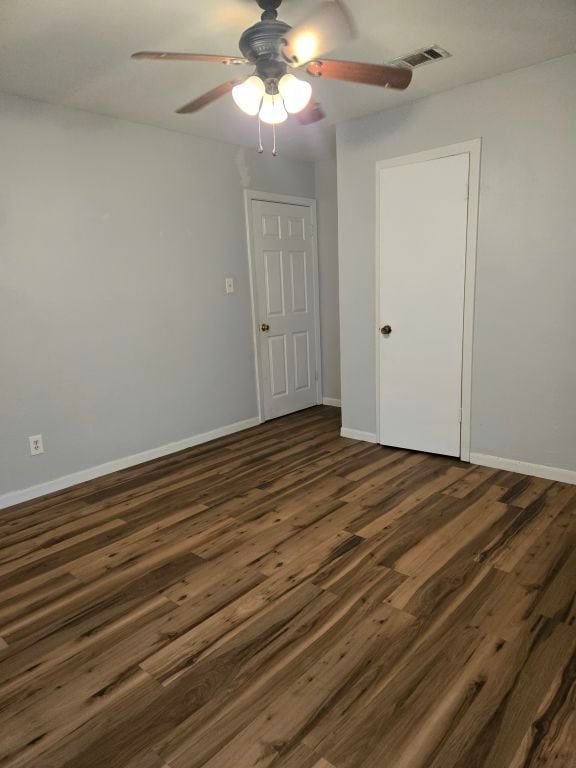 spare room featuring dark hardwood / wood-style floors and ceiling fan