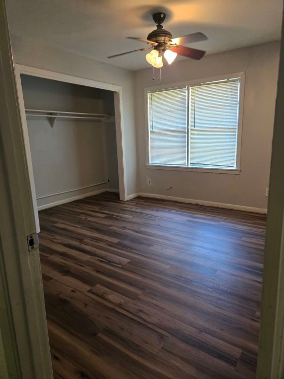 unfurnished bedroom featuring a closet, ceiling fan, and dark hardwood / wood-style flooring