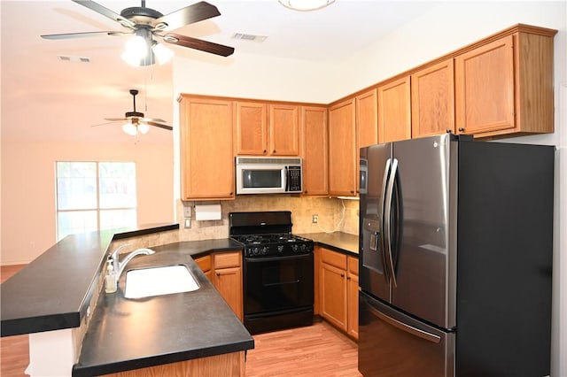 400 Princeton Cir, College Station, TX 77840 - kitchen with stainless steel fridge with ice dispenser, black range with gas cooktop, dark countertops, a peninsula, and a ceiling fan