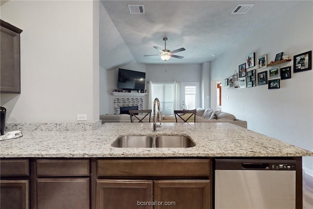 kitchen featuring kitchen peninsula, light stone countertops, ceiling fan, sink, and dishwasher