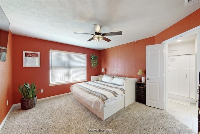 carpeted bedroom featuring a textured ceiling, connected bathroom, and ceiling fan