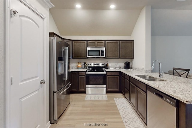 kitchen with lofted ceiling, sink, kitchen peninsula, and stainless steel appliances