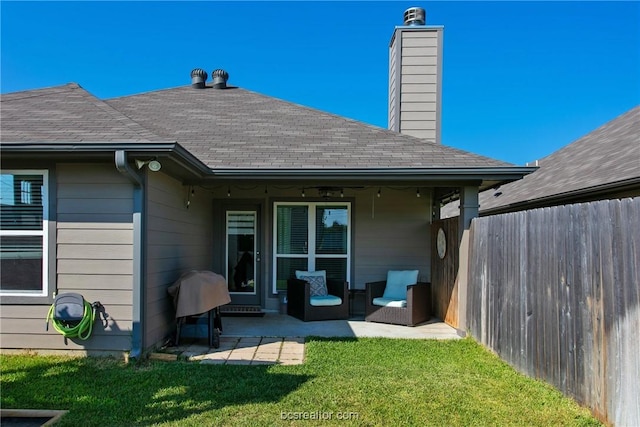 rear view of property with a yard and a patio area