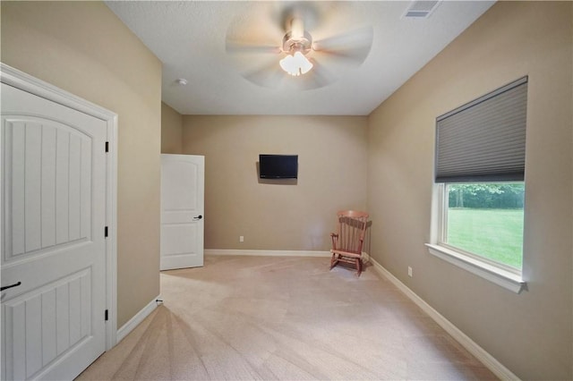 spare room with light colored carpet and ceiling fan