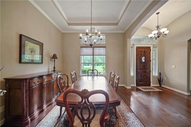 dining room featuring ornamental molding, dark wood-type flooring, a raised ceiling, and a notable chandelier