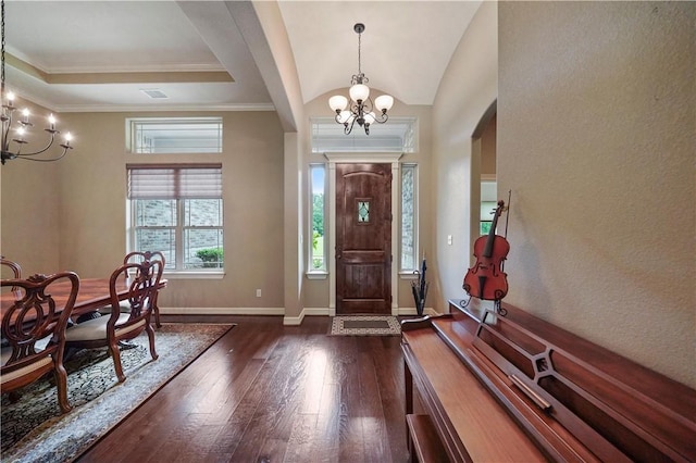 entrance foyer featuring a tray ceiling, ornamental molding, dark hardwood / wood-style floors, and a notable chandelier