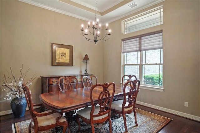 dining area with ornamental molding, dark wood-type flooring, and an inviting chandelier