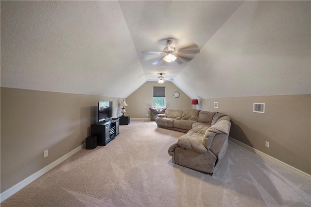 carpeted living room with ceiling fan, lofted ceiling, and a textured ceiling