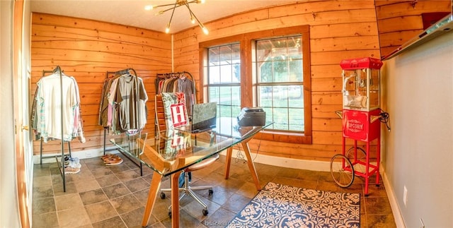 dining space with wood walls and a notable chandelier