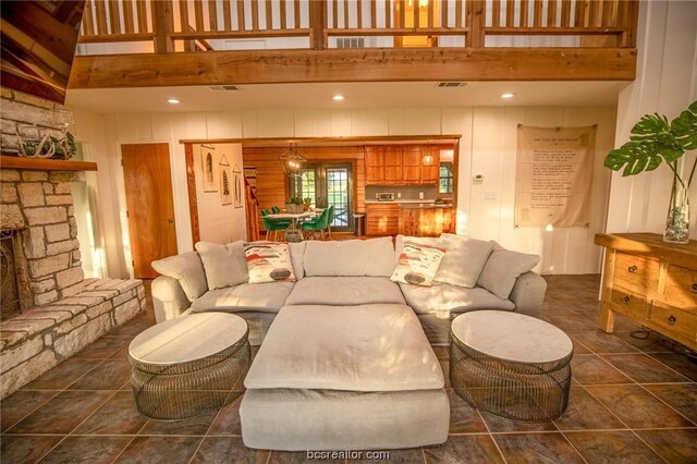 living room featuring a fireplace and a towering ceiling