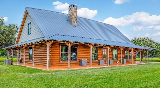 rear view of property with a lawn, a porch, and central air condition unit