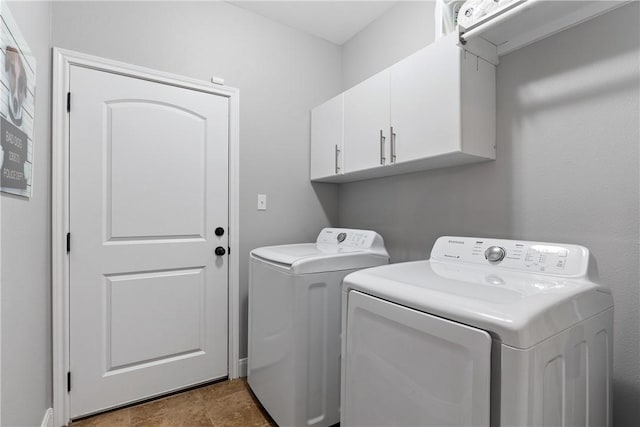 washroom featuring washer and clothes dryer and cabinets