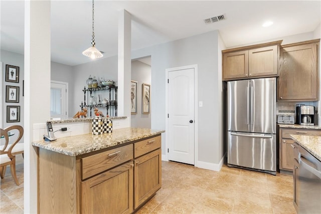 kitchen featuring light stone counters, stainless steel appliances, decorative light fixtures, and backsplash