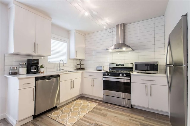 kitchen featuring white cabinets, wall chimney exhaust hood, and stainless steel appliances