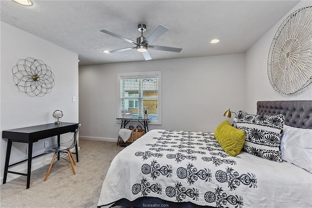 carpeted bedroom featuring ceiling fan and a textured ceiling