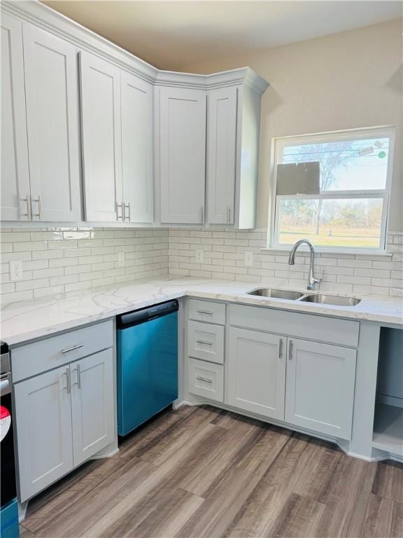 kitchen with white cabinetry, sink, light hardwood / wood-style flooring, and stainless steel dishwasher