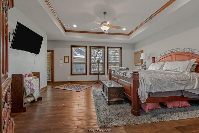 bedroom with a raised ceiling, ceiling fan, dark hardwood / wood-style floors, and ornamental molding