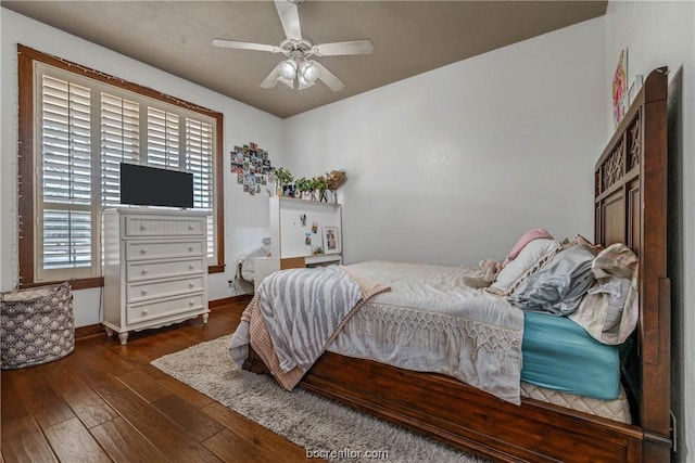 bedroom with dark hardwood / wood-style flooring and ceiling fan