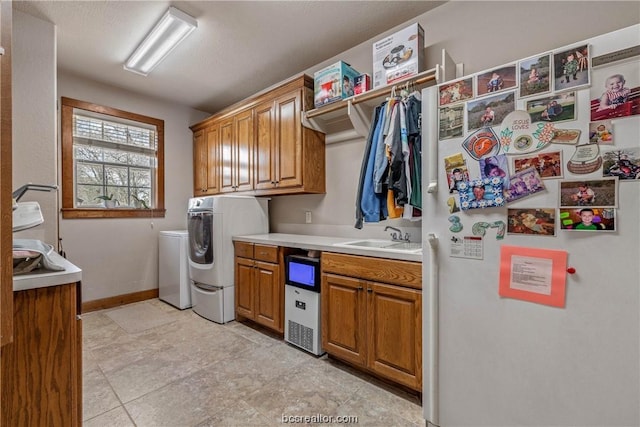 washroom featuring cabinets, sink, and washing machine and dryer