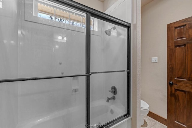 bathroom with enclosed tub / shower combo and toilet