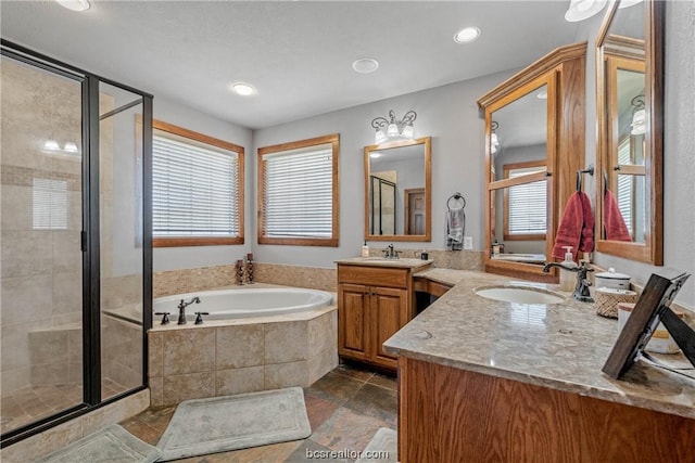 bathroom with vanity, a healthy amount of sunlight, and separate shower and tub