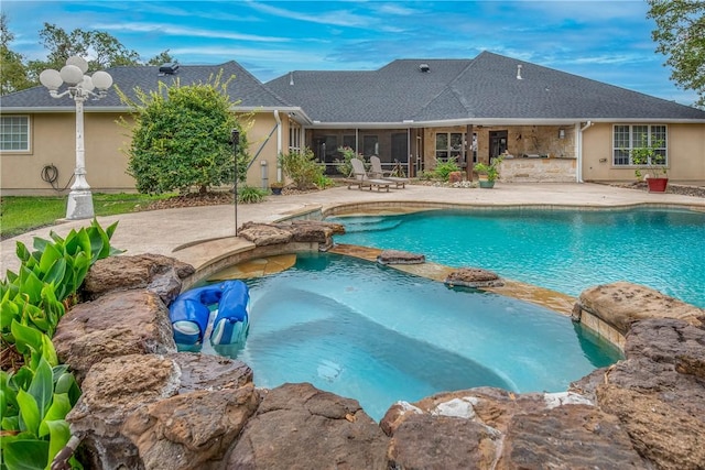 view of pool with an in ground hot tub, a patio, and a sunroom