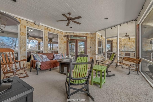 sunroom / solarium with ceiling fan and french doors