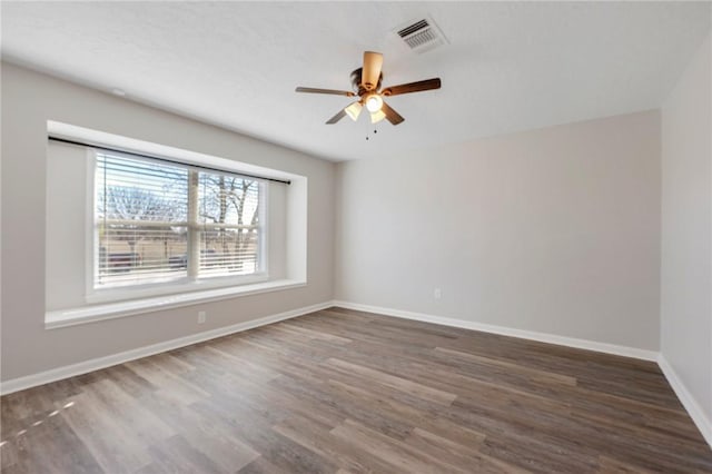 unfurnished room with dark hardwood / wood-style flooring and ceiling fan