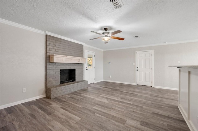 unfurnished living room featuring a textured ceiling, ceiling fan, dark wood-type flooring, crown molding, and a fireplace