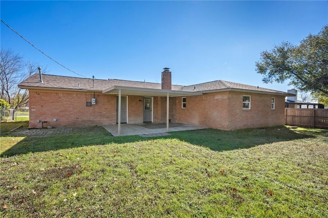 rear view of property with a yard and a patio area