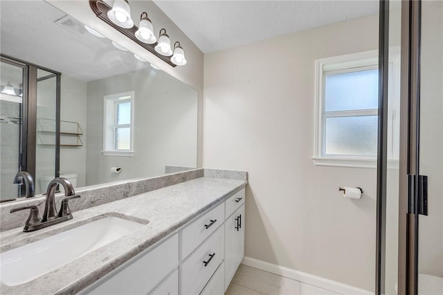 bathroom with tile patterned floors, a wealth of natural light, vanity, and a textured ceiling