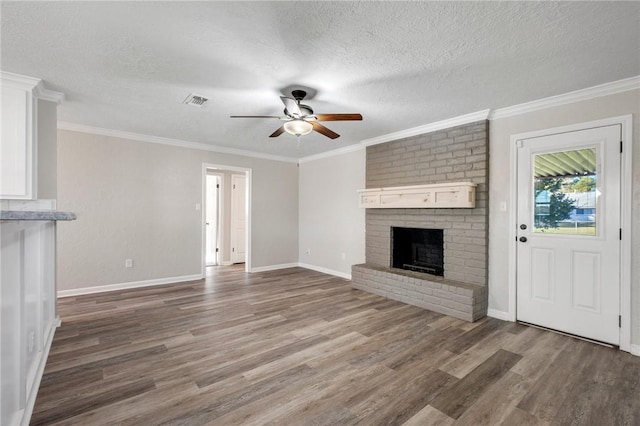 unfurnished living room with ceiling fan, crown molding, wood-type flooring, a textured ceiling, and a fireplace