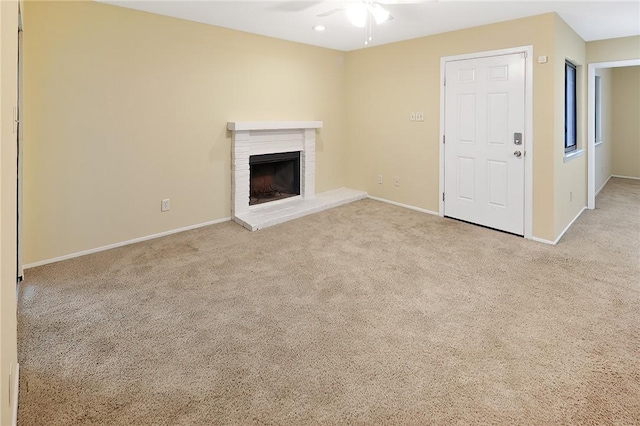 unfurnished living room featuring light carpet, a fireplace, and ceiling fan