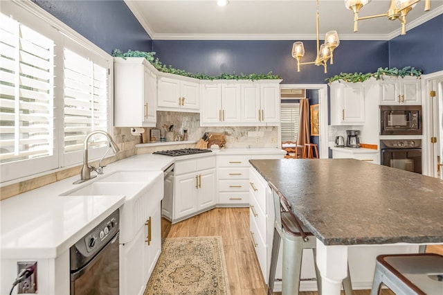 kitchen featuring decorative backsplash, crown molding, black appliances, an inviting chandelier, and light wood finished floors