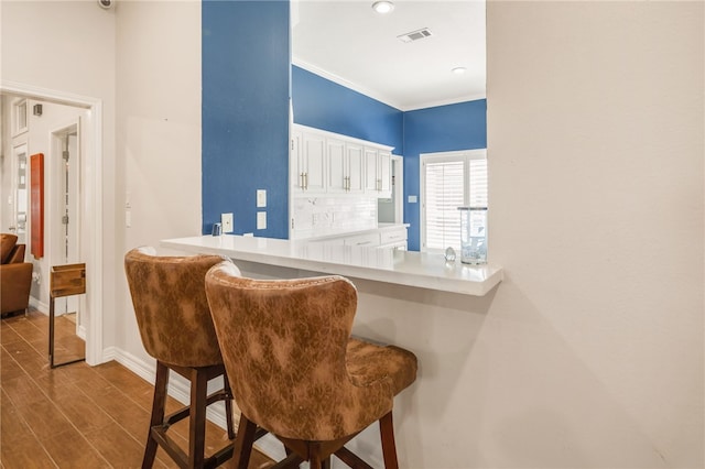 interior space with visible vents, baseboards, backsplash, and dark wood-style flooring