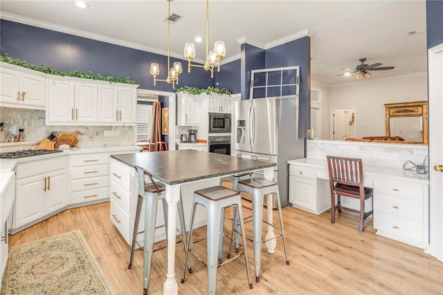 kitchen with appliances with stainless steel finishes, visible vents, decorative backsplash, and ornamental molding