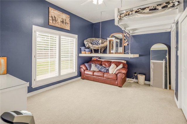 living area featuring a ceiling fan, carpet, and baseboards
