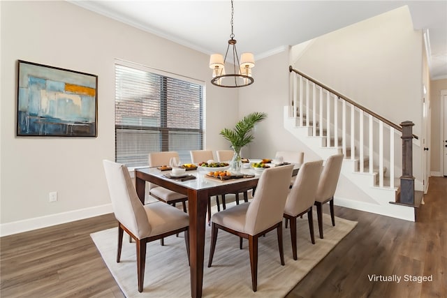 dining area with dark wood-type flooring, crown molding, and a notable chandelier