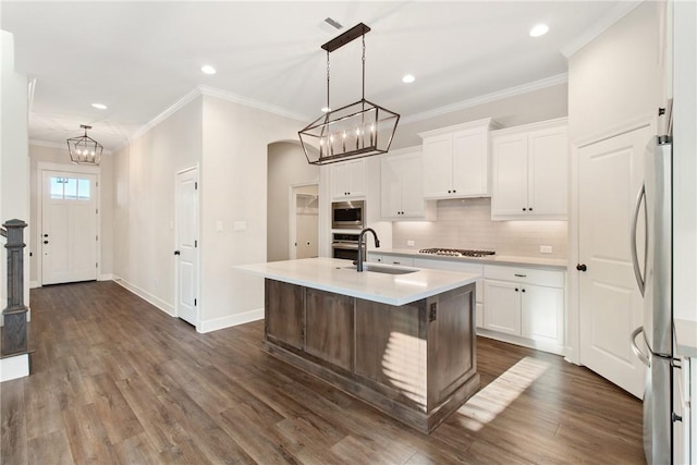 kitchen featuring stainless steel appliances, sink, pendant lighting, white cabinets, and an island with sink