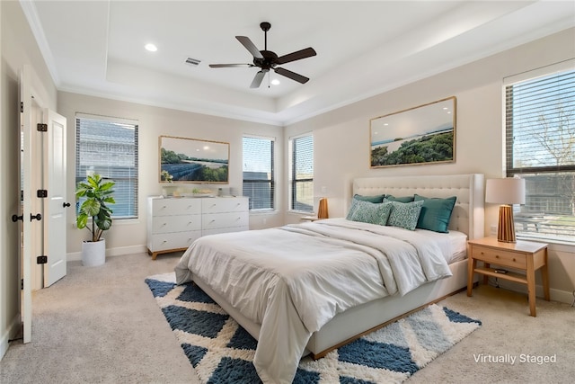 carpeted bedroom featuring ceiling fan, ornamental molding, and a tray ceiling