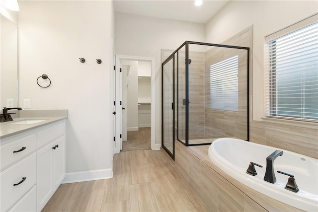 bathroom with vanity and shower with separate bathtub