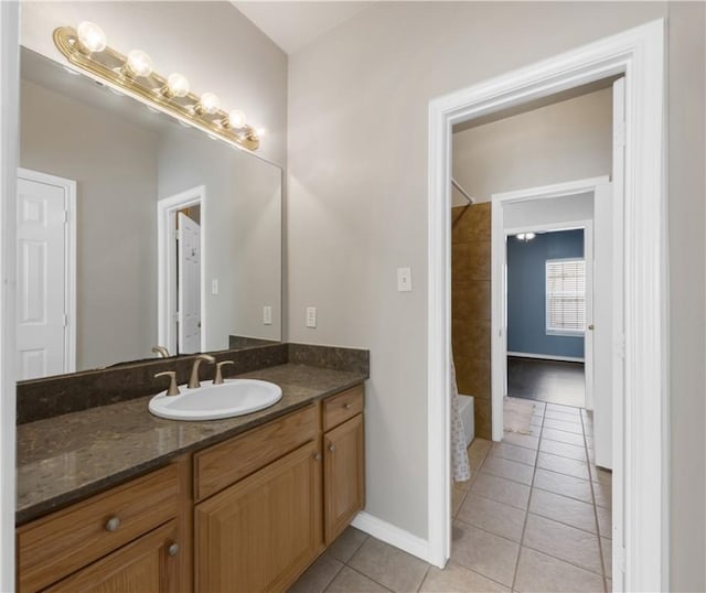 bathroom with tile patterned flooring, bathtub / shower combination, vanity, and baseboards