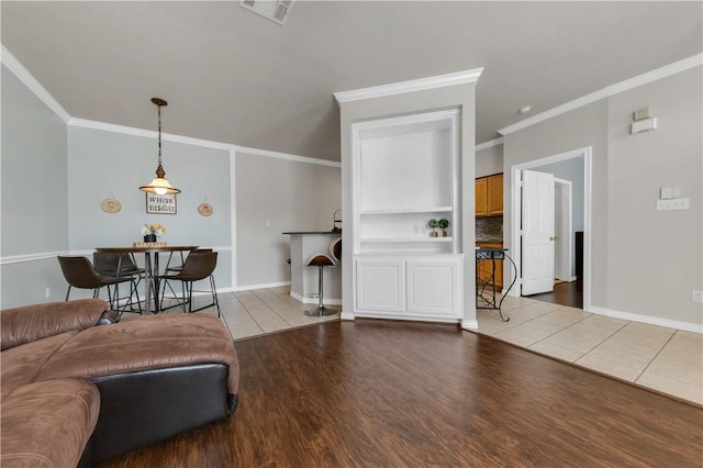 living room featuring visible vents, ornamental molding, and wood finished floors