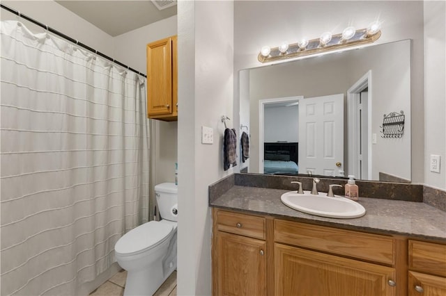 ensuite bathroom with tile patterned flooring, connected bathroom, toilet, a shower with shower curtain, and vanity