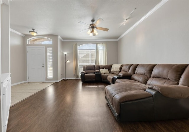 living room with wood finished floors, ornamental molding, and a ceiling fan