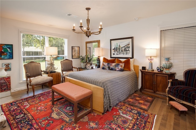 bedroom with a notable chandelier and light hardwood / wood-style flooring