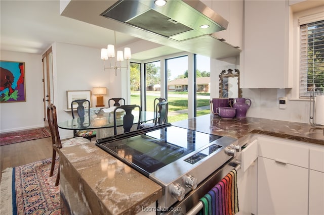 kitchen with extractor fan, white cabinetry, hanging light fixtures, stainless steel electric stove, and hardwood / wood-style floors